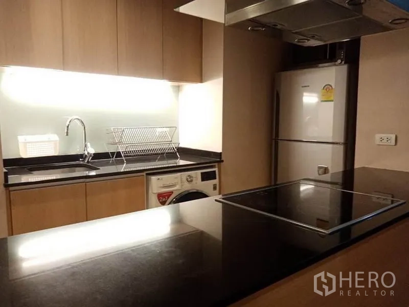 公寓 出租在Sathon, Bangkok - 近景厨房岛台，水槽与背板，电陶炉和抽油烟机。