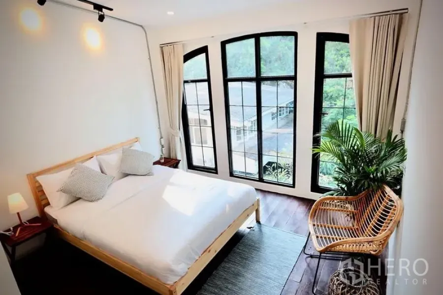 ทาวน์เฮาส์ ให้เช่าในSathon, Bangkok - ห้องนอนสว่าง หน้าต่างโค้งกรอบอลูมิเนียมสีดำ เตียงไม้และเก้าอี้หวาย
