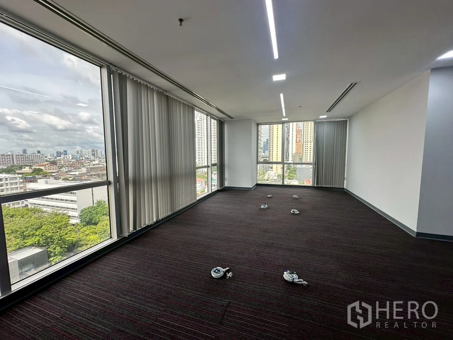 Office Space for rent - Corner office with floor-to-ceiling windows, vertical blinds and skyline outlook.