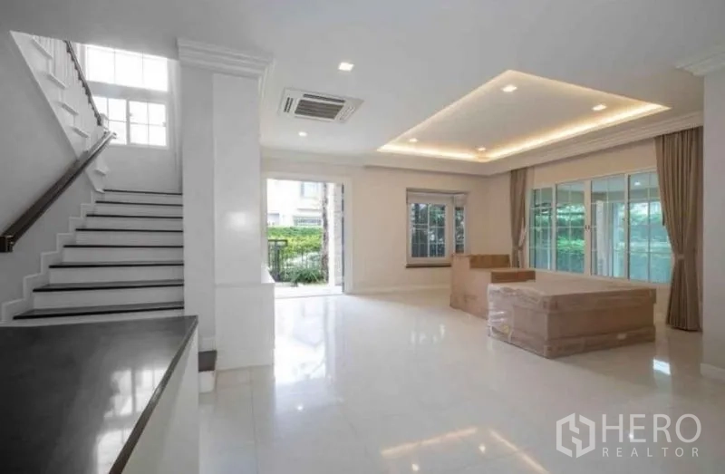 Detached House for rent or sale in Bang Phli, Samut Prakan - Spacious living room with recessed ceiling lights, large windows, sliding doors and a stairway.