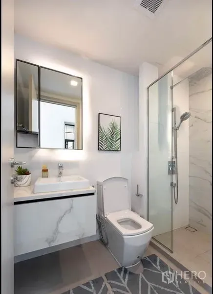 公寓 出租在Phra Khanong, Bangkok - 现代白色浴室，玻璃淋浴间与洗手台。