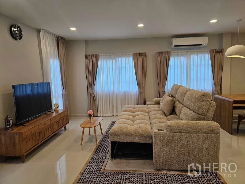 Detached House for rent in Bang Phli, Samut Prakan - Living room focus on reclining sectional sofa, TV unit and air-conditioning.
