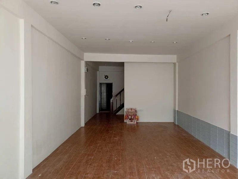 อาคารพาณิชย์ ให้เช่าในWatthana, Bangkok - พื้นที่ชั้นล่างโล่ง ผนังสีขาว พื้นลายไม้ และไฟดาวน์ไลท์