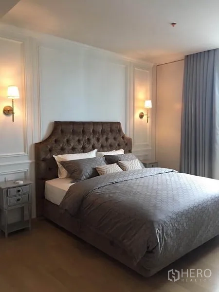 คอนโด ให้เช่าในPhaya Thai, Bangkok - ห้องนอนหลักหัวเตียงบุนวม โคมไฟผนัง และชุดเครื่องนอนสีเทา