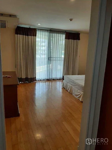 อพาร์ทเมนท์ ให้เช่าในWatthana, Bangkok - ห้องนอนสว่างด้วยพื้นไม้ ผ้าม่านทึบโปร่ง และเตียงควีนไซซ์
