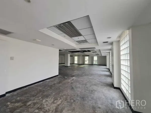 สำนักงาน ให้เช่าในRatchathewi, Bangkok - ออฟฟิศโล่งสว่าง พื้นคอนกรีต เพดานแขวนโคมไฟ หลายเสารับน้ำหนัก และผนังบล็อกแก้วยาว ใกล้ BTS ราชเทวี