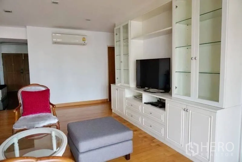 Condominium for rent in Watthana, Bangkok - Lounge corner featuring a white built-in TV cabinet with glass display shelving.