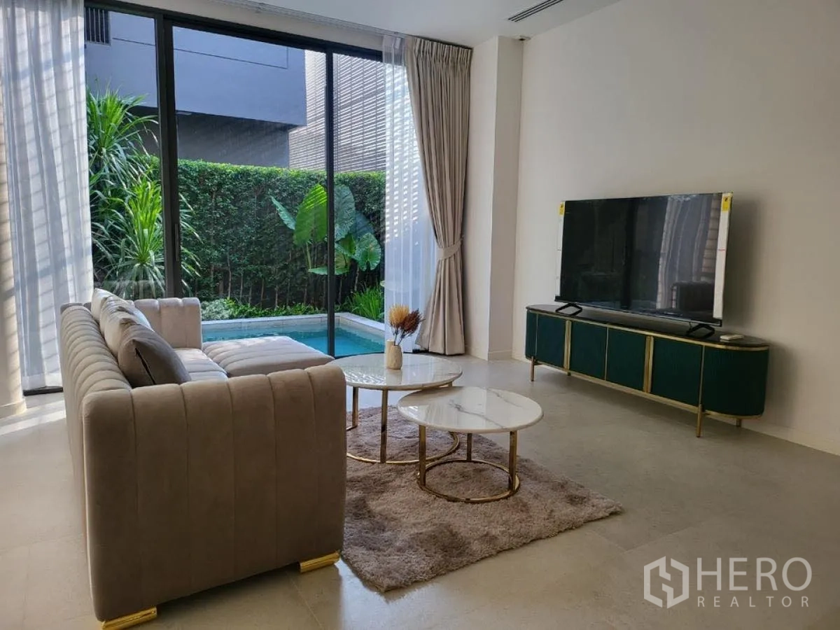 บ้าน ให้เช่าในWang Thonglang, Bangkok - ห้องนั่งเล่นสว่าง โซฟาและชั้นวางทีวี เปิดออกสู่สระว่ายน้ำส่วนตัวผ่านประตูกระจกบานเลื่อน