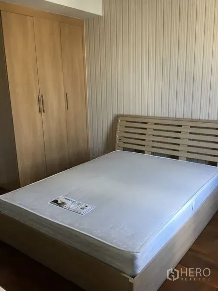 คอนโด ให้เช่าในKhlong Toei, Bangkok - ห้องนอนโทนไม้พร้อมเตียงและตู้เสื้อผ้าบิวท์อิน ผนังลายเส้น