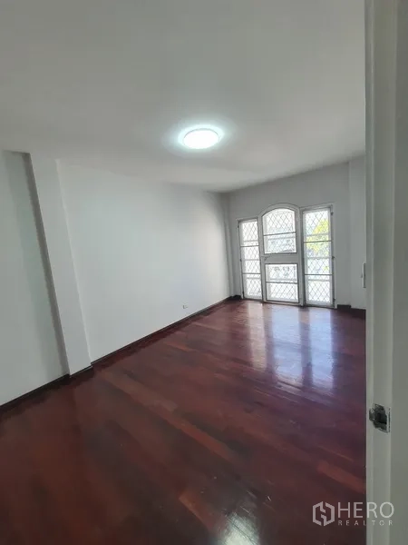 联排别墅 出售在Khlong Toei, Bangkok - 明亮卧室，抛光木地板，带双开阳台门及防护栏。