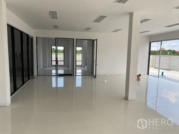 Warehouse for rent or sale in Bang Len, Nakhon Pathom - Open-plan office area with glass partitions and sliding doors connecting to an outdoor terrace.