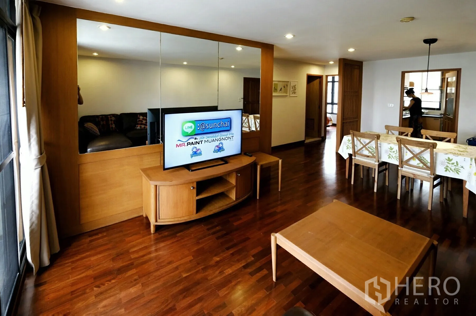 คอนโด ให้เช่าในWatthana, Bangkok - โถงนั่งเล่น–รับประทานอาหาร พร้อมตู้คอนโซลทีวี ผนังกระจกเงา และพื้นไม้