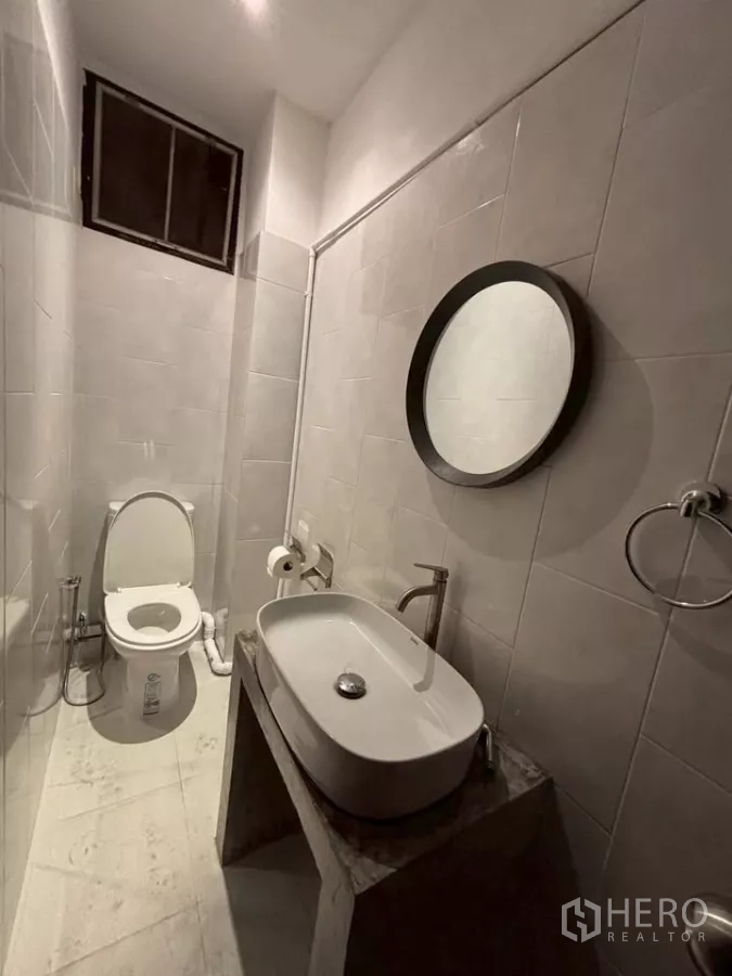 店屋 出租在Watthana, Bangkok - 白色瓷砖卫生间，圆镜与台上盆。