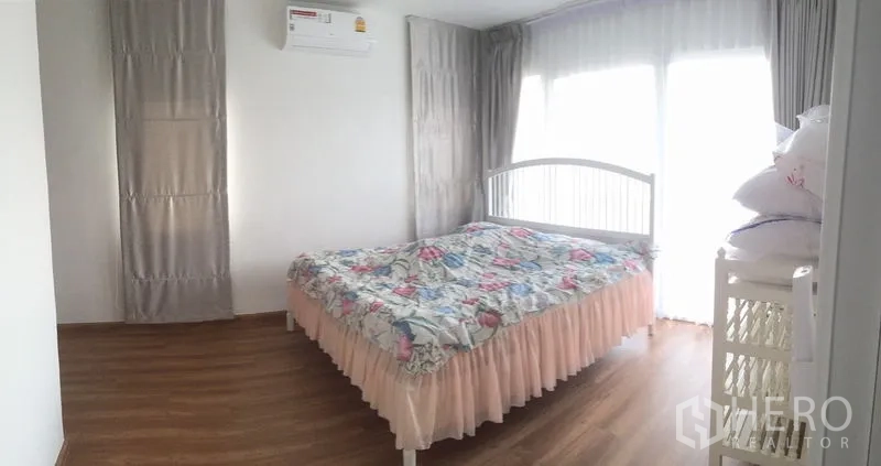Detached House for sale in Prawet, Bangkok - Bedroom with wood flooring, double bed and large curtained windows.