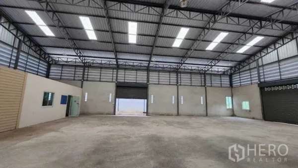 คลังสินค้า ให้เช่าในChon Buri - โกดังโล่งกว้าง เพดานโครงเหล็กสูง มีแผ่นสกายไลต์และประตูม้วนกลางอาคาร