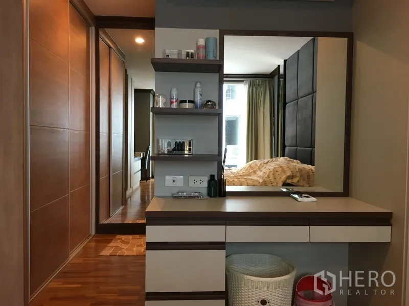 公寓 出售在Khlong Toei, Bangkok - 卧室过道的梳妆台，带大镜子与开放搁架。