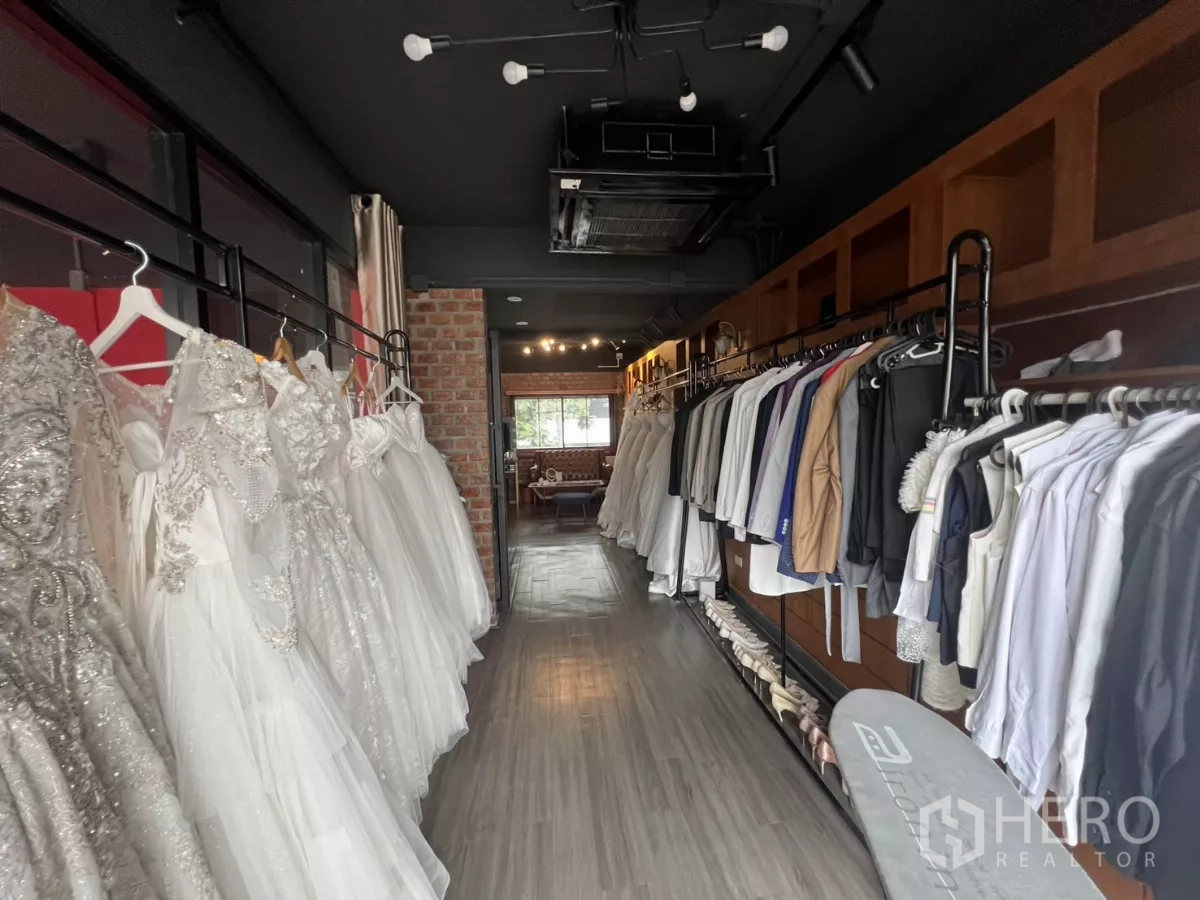 零售空间 出租在Watthana, Bangkok - 长形试衣走道，两侧婚纱与西装挂架成列。
