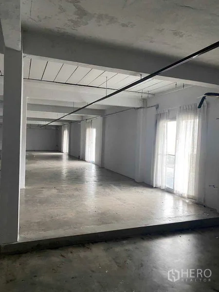 零售空间 出租在Bang Na, Bangkok - 明亮角落，落地窗帘与台阶高度变化。