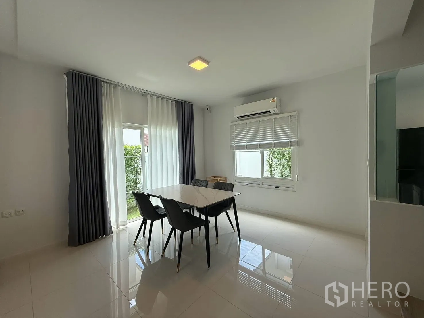 บ้านเดี่ยว for rent in Bang Phli, Samut Prakan - พื้นที่รับประทานอาหารสว่างพร้อมโต๊ะหินอ่อน เก้าอี้สี่ตัว ผ้าม่าน และประตูสู่สวน