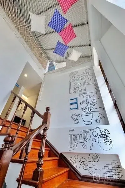 อาคารพาณิชย์ ให้เช่าในPathum Wan, Bangkok - บันไดไม้พร้อมผนังลายกราฟิก และตาข่ายเพดานแขวนหมอนตกแต่ง