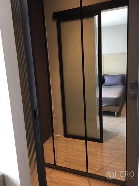 Condominium for rent in Watthana, Bangkok - Hallway with mirrored sliding wardrobe doors facing the bedroom.