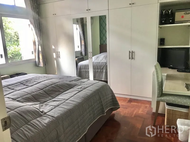 独立式住宅 出租 - 采光卧室，内置白色衣柜、书桌、窗户与人字纹木地板。