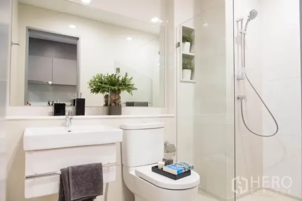 คอนโด ขายในRatchathewi, Bangkok - ห้องน้ำสว่างสไตล์โมเดิร์น มีกระจกบานใหญ่ อ่างล้างหน้า โถสุขภัณฑ์ และตู้ชาวเวอร์กระจก