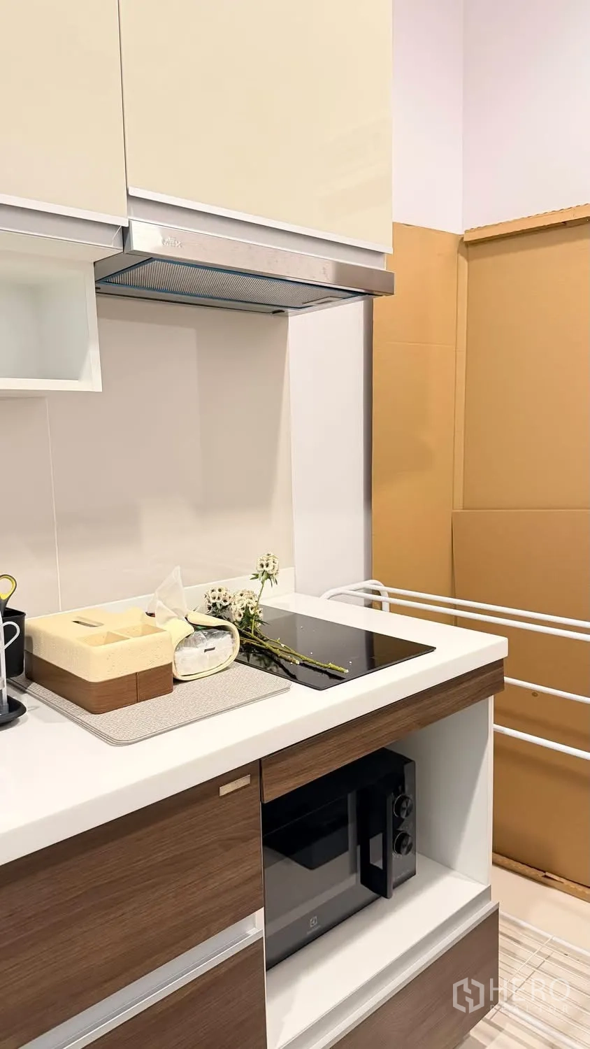 Condominium for rent in Watthana, Bangkok - Compact kitchenette featuring an induction hob, hood, and built-in microwave.