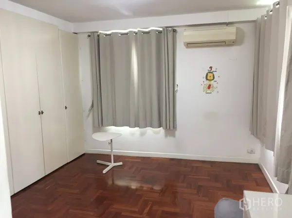 Condominium for rent in Sathon, Bangkok - Bright spare room in a Sathon condo with built-in wardrobes, grey curtains, wall air-conditioner and parquet wood flooring.