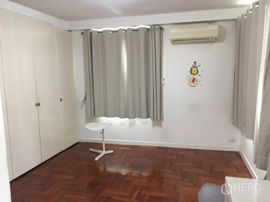 Condominium for rent in Sathon, Bangkok - Bright spare room in a Sathon condo with built-in wardrobes, grey curtains, wall air-conditioner and parquet wood flooring.