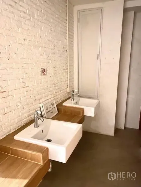 店屋 出租在Phaya Thai, Bangkok - 洗手区，双方形洗手盆与白色砖墙、木质台面