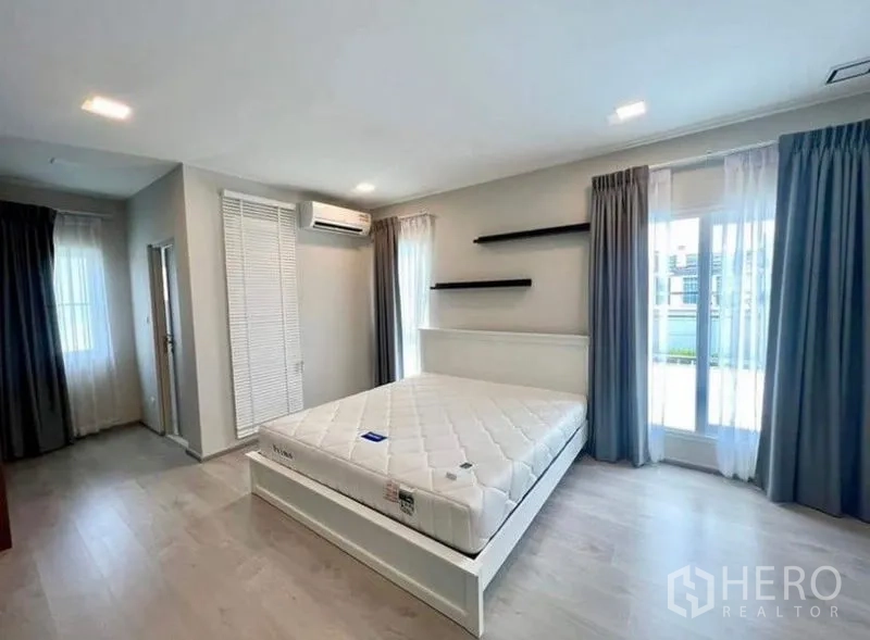 บ้าน ให้เช่า - ห้องนอนใหญ่มีประตูกระจกออกระเบียง เครื่องปรับอากาศ และพื้นไม้โทนอ่อน