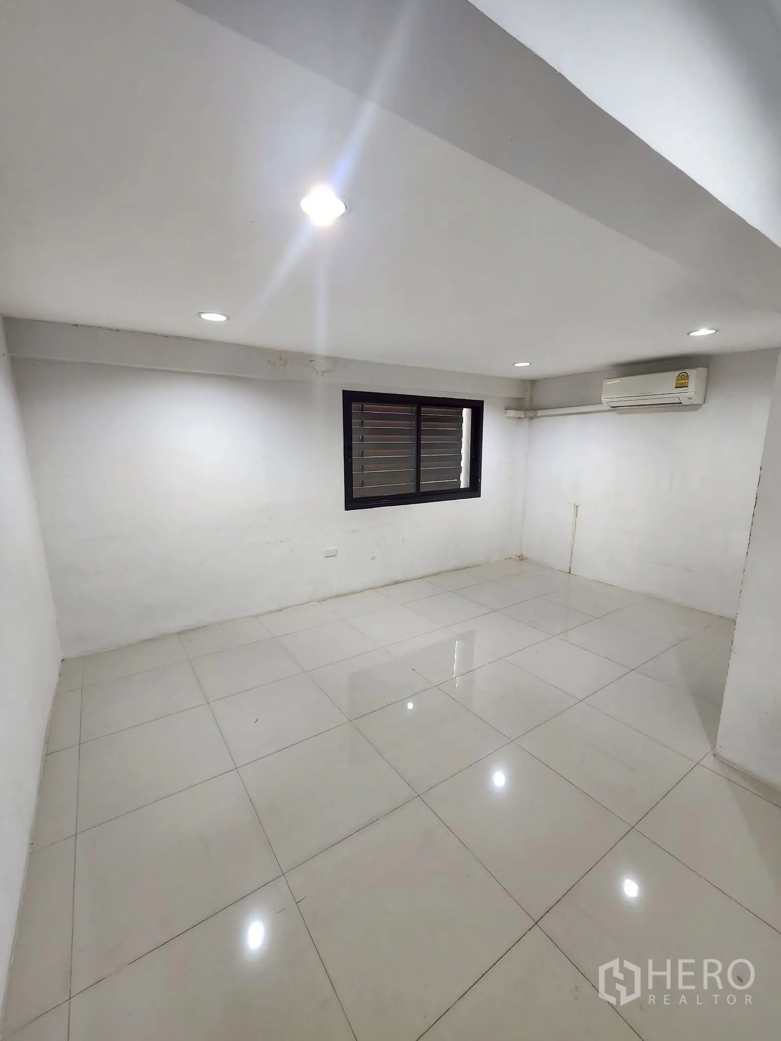 โฮมออฟฟิศ for rent in Khlong Toei, Bangkok - ห้องทรงสี่เหลี่ยม พื้นกระเบื้องสีขาวเงา มีหน้าต่างบานเกล็ดและแอร์ผนัง