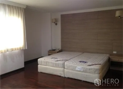 คอนโด ให้เช่าในWatthana, Bangkok - ห้องนอนกว้าง วางที่นอนคู่ ผนังหัวเตียงลายผ้า โต๊ะข้างเตียง และแสงธรรมชาติ