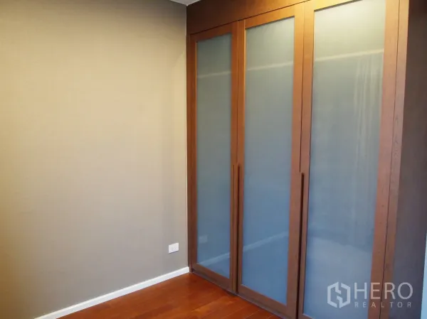 คอนโด ให้เช่าหรือขายในWatthana, Bangkok - มุมห้องนอนพร้อมตู้เสื้อผ้าบิลท์อินบานเลื่อนกระจกฝ้า พื้นไม้