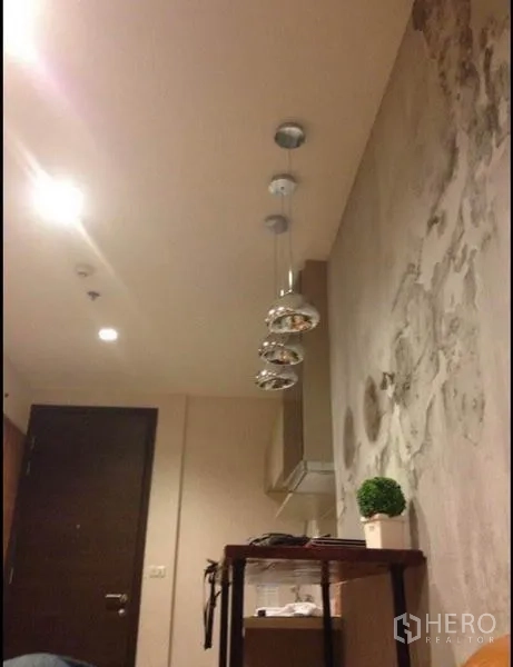 公寓 出售在Phaya Thai, Bangkok - 入口区，吊灯悬于窄吧台上方，搭配水泥质感墙面。