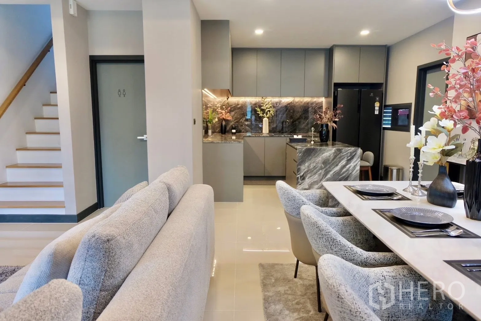 Semi-detached House for sale in Prawet, Bangkok - Open-plan living, dining and kitchen with staircase in view.