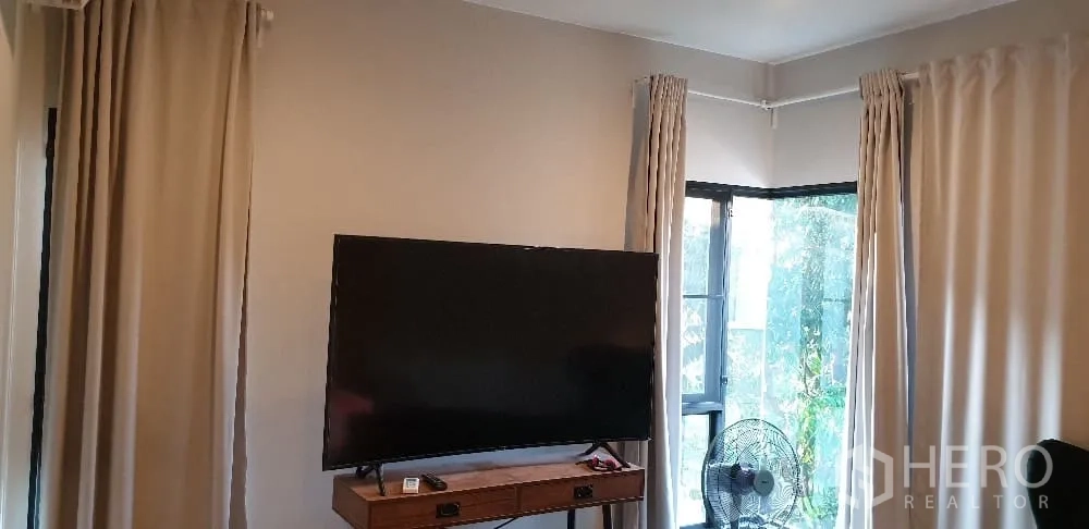 บ้าน ให้เช่าหรือขายในLam Luk Ka, Pathum Thani - มุมทีวี จอแบนขนาดใหญ่ ผ้าม่าน และหน้าต่าง