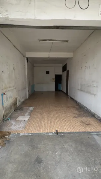 Shophouse for rent in Chatuchak, Bangkok - Front bay of the shophouse showing utility tap, long tiled floor and concrete apron for loading or parking.