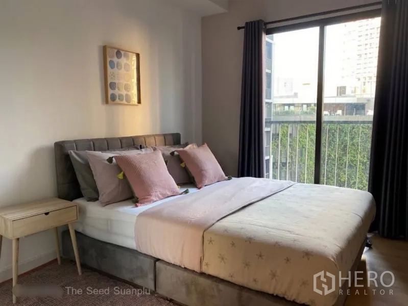 Condominium for rent or sale in Sathon, Bangkok - Cozy bedroom with upholstered bed, large window and balcony outlook.