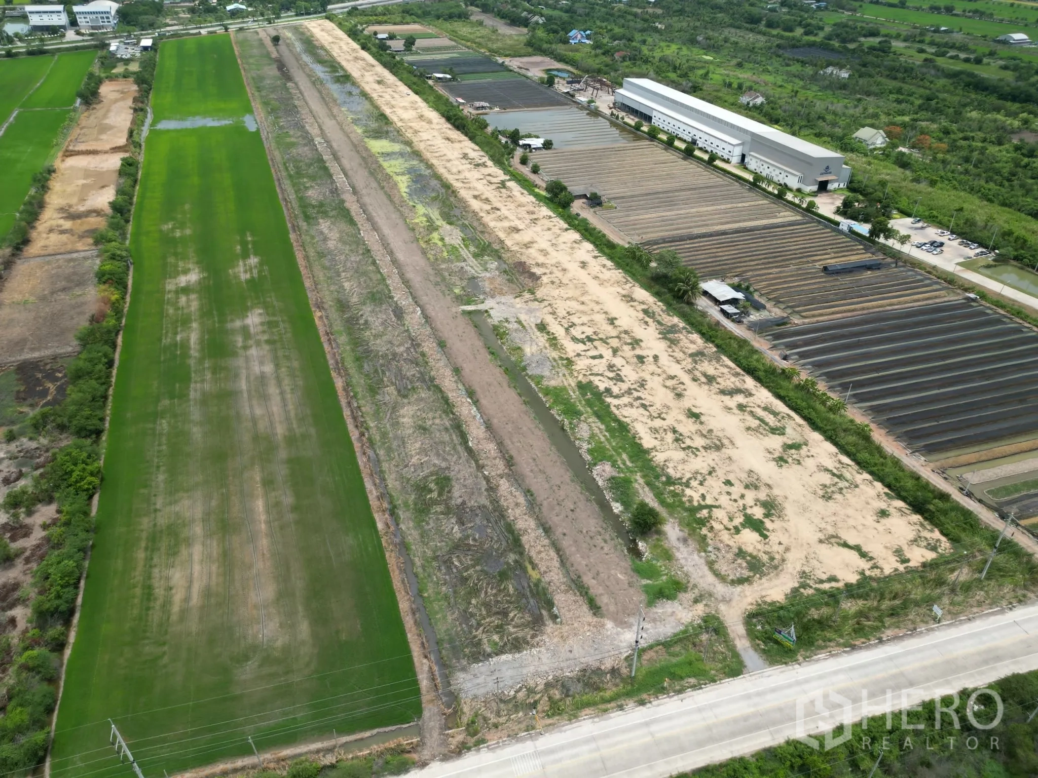 Land for sale in Sai Noi, Nonthaburi - Top-down view of the plot running beside cultivated fields and an accessible public road.