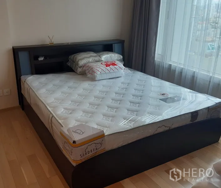 คอนโด ให้เช่าในKhlong Toei, Bangkok - ห้องนอนสว่าง เตียงขนาดใหญ่ พื้นไม้โทนอ่อน ข้างหน้าต่างบานกว้างมองเห็นวิวเมือง