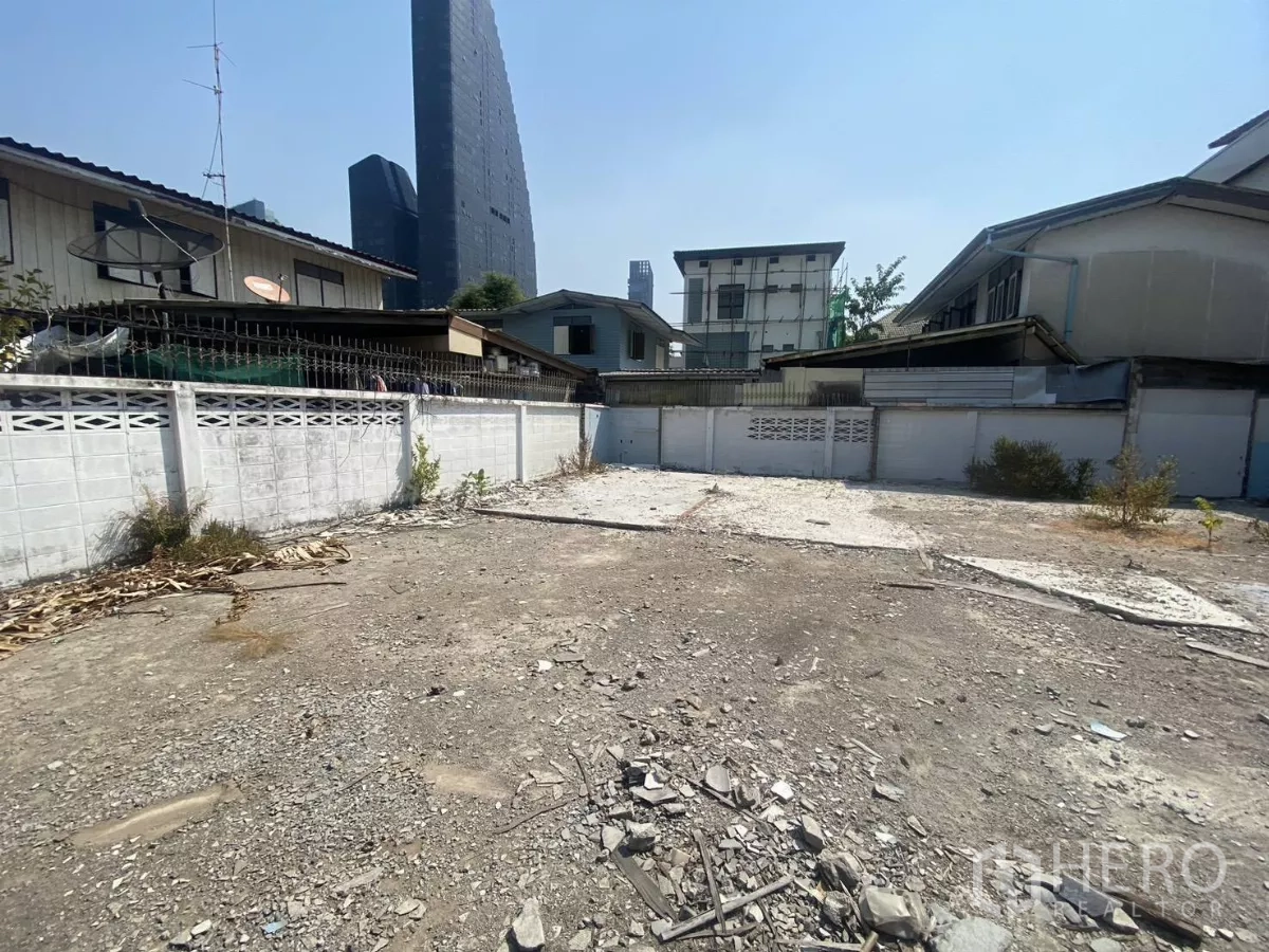Land for rent in Khlong Toei, Bangkok - Open cleared land within a low-rise neighborhood, city skyline visible in Khlong Toei, Bangkok.