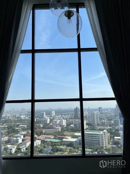 公寓 出租在Sathon, Bangkok - 透过高窗眺望曼谷天际线与城市景观的晴天视野。