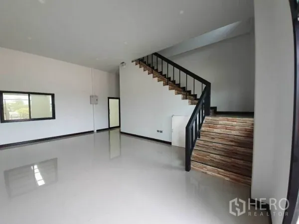 工厂 出租在Mueang Samut Sakhon, Samut Sakhon - 厂房内部明亮的办公区，亮面地砖与木质楼梯通往楼上工作区。