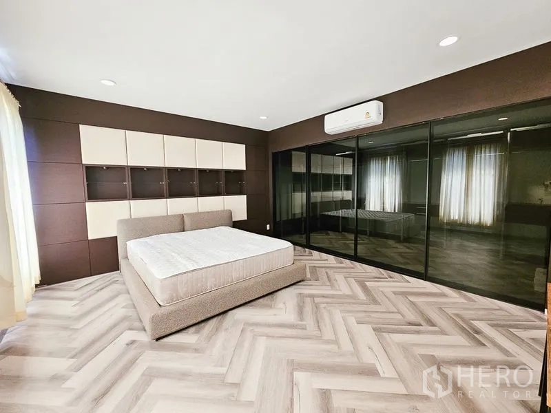 Townhouse for rent in Yan Nawa, Bangkok - Spacious master bedroom with feature wall, air-conditioning and mirrored wardrobes.