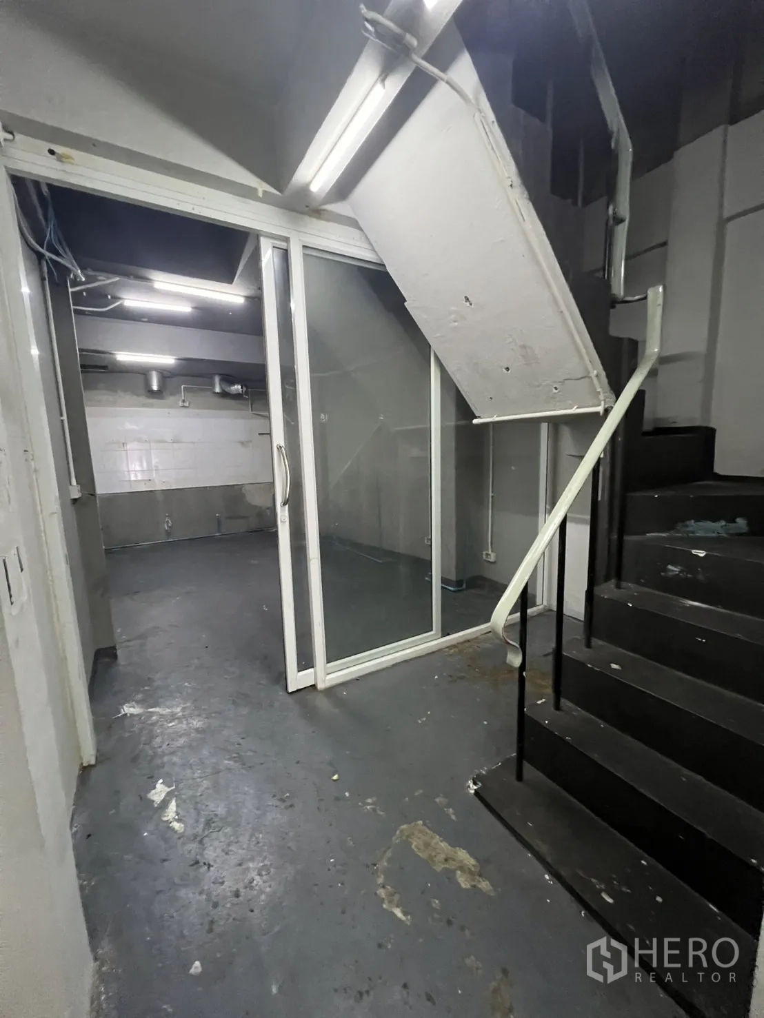 店屋 出租在Watthana, Bangkok - 后方服务区，黑色楼梯与玻璃推拉门。