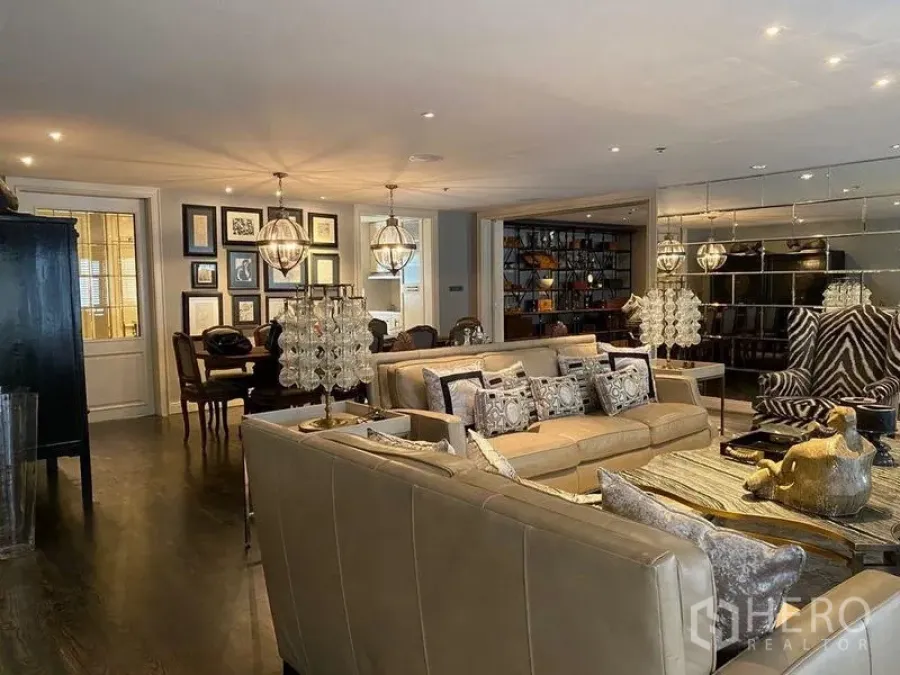 Condominium for rent in Khlong San, Bangkok - Spacious open‑plan living and dining area with crystal lamps and a statement armchair.