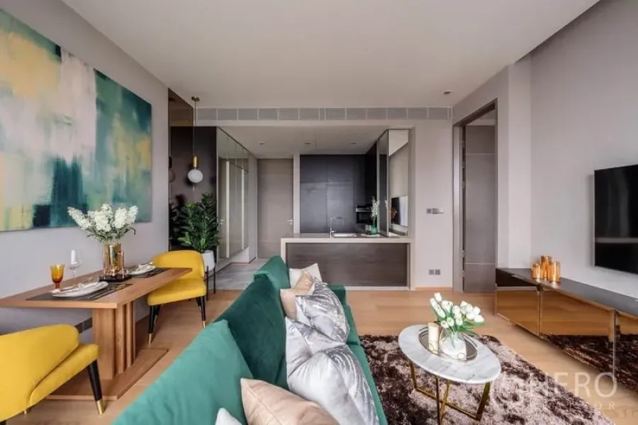 公寓 出租或出售在Bang Rak, Bangkok - 开放式客厅，祖母绿沙发、餐桌与现代开放式厨房。