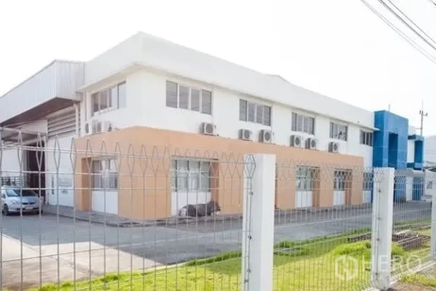 Factory for rent in Chachoengsao - Side view of two-storey office block with multiple air-conditioning units.